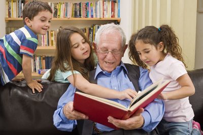 grandfather reading to 3 preschoolers